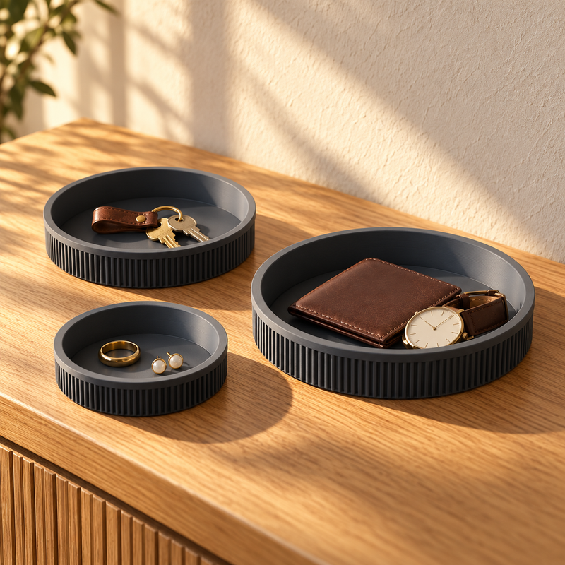 Set of three charcoal ribbed round trays in graduated sizes on an oak console. Jewellery, keys, wallet and watch are styling accessories, not included.
